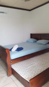 a bed with a wooden frame and blue sheets at Cabinas Smith 2 in Cahuita