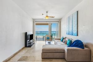 a living room with a couch and a television at Watermark Luxury Oceanfront Residences in Cabarete
