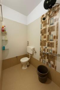 a bathroom with a toilet and a bucket in it at Heartistry in Jabalpur