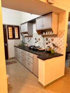 a kitchen with white cabinets and a black counter top at Heartistry in Jabalpur