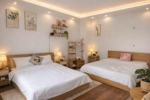 a bedroom with two beds and two tables and lamps at Solia Villa in Danang +17 photos