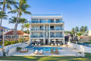 an apartment building with a swimming pool and palm trees at Watermark Luxury Oceanfront Residences in Cabarete