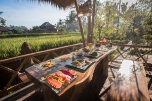 a table with food on it next to a rice field at Serenity Villa & Spa in Ubud
