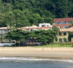 a house on the beach next to the water at Apartamento familiar com acesso privativo à Praia Mansa in Matinhos