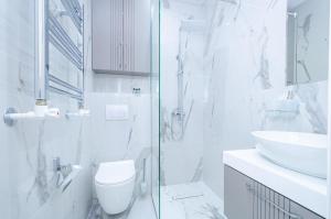 a white bathroom with a toilet and a sink at 31Mesrop Mashtots Avenu in Yerevan