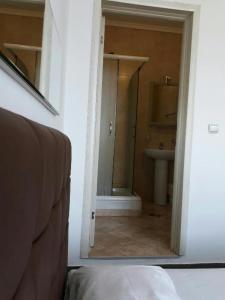 a bathroom with a mirror and a sink and a toilet at Double room H Požarevac in Požarevac
