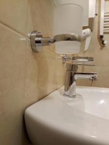 a bathroom with a white toilet and a sink at Double room H Požarevac in Požarevac