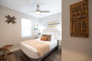 a bedroom with a bed with white sheets and a wooden floor at Sunflower Beach Cottage in Ocean Shores