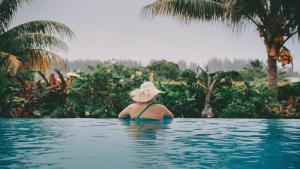 a woman wearing a hat in a swimming pool at Avaiki Nui Villa in Avarua