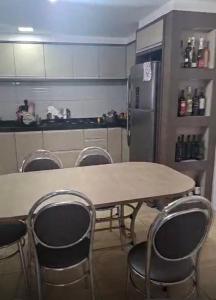 a kitchen with a table and chairs and a refrigerator at Aconchego in Cascavel