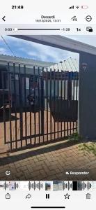 a picture of a gate in front of a building at Aconchego in Cascavel