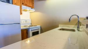 a kitchen with a sink and a white refrigerator at Cahilty #454 home in Sun Peaks