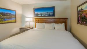a bedroom with a white bed and a desk with a lamp at Cahilty #454 home in Sun Peaks