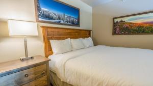 a bedroom with a bed and a table with a lamp at Cahilty #454 home in Sun Peaks