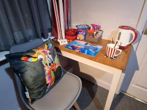 a desk with a chair next to a table with a table at Pride Lodge in Blackpool