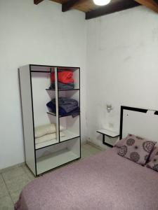 a bedroom with a glass cabinet next to a bed at Tu Destino in San José