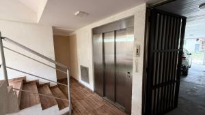 a hallway with a metal door in a building at Apê de Mainha in Ilhéus