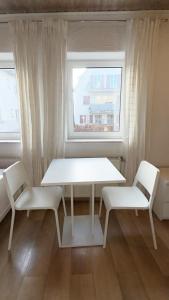 a white table and two chairs in a room with a window at Haus Leipheim in Leipheim
