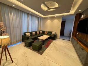 a living room with a couch and a tv at Conifer heights in Shimla