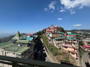 a group of buildings on the side of a hill at Conifer heights in Shimla