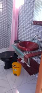 a bathroom with a red sink and a toilet at Hospedaje Tío Tom in Bernardo de Irigoyen