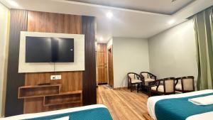 a hotel room with a flat screen tv on a wall at Yatram in Rishīkesh