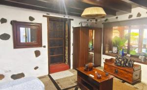 a room with a bed and a table and a door at Finca Lucía - Los Hervideros in Mácher