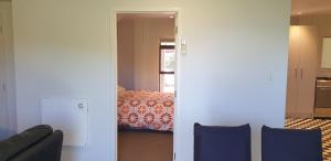 a room with a bedroom with a bed and a couch at Lazy Daze at Athenree in Waihi Beach