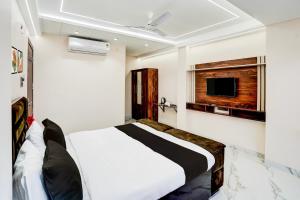 a bedroom with a white bed and a tv at Super Collection O Ganeshpuri Indore in Indore +41 photos