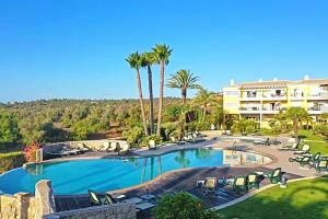 a resort with a large swimming pool with palm trees at Casa Foz da Ria in Lagos
