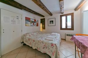 1 dormitorio con cama, mesa y ventana en In the heart of BIENNALE ac wi-fi, en Venecia