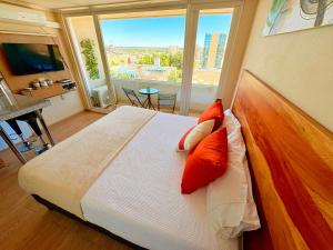 a bedroom with a large bed and a large window at DEPARTAMENTO ACOGEDOR Y TRANQUILO en Chillán Centro, full equipado, ideal para descansar, Wifi y Estacionamiento in Chillán +37 photos