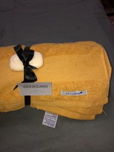 a yellow towel with a black bow on top of it at ApartCarina in General Acha