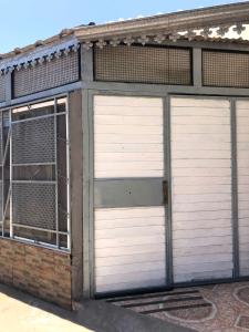 two white garage doors on a brick building at ApartCarina in General Acha