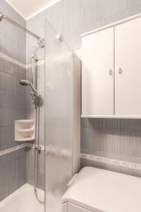 a bathroom with a shower with a glass door at Maison Leti Comfort Studio in Bellagio