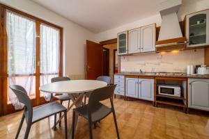 a kitchen with a table and chairs in a room at Primula Comfort Apartment in Bellagio