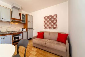 a living room with a couch and a kitchen at Primula Comfort Apartment in Bellagio