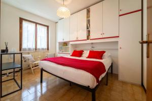 a bedroom with a large bed with red pillows at Primula Comfort Apartment in Bellagio