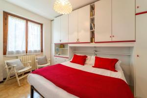 a bedroom with a large bed with two red pillows at Primula Comfort Apartment in Bellagio +6 photos