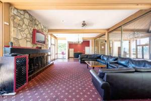 a living room with leather couches and a stone wall at Luxury Condo Resort Amenities - Pool, Pickleball in San Diego
