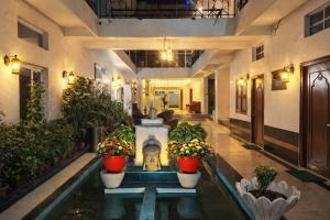 a lobby with a fountain and potted plants at Hotel Harmony in Khajurāho