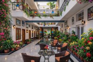 a lobby with tables and chairs and flowers at Hotel Harmony in Khajurāho
