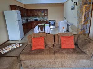 a living room with a brown couch with orange pillows at Parrot Heights in Micoud