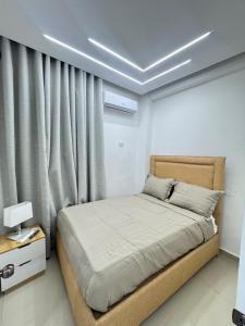 ein Schlafzimmer mit einem Bett und einem Fenster mit Vorhängen in der Unterkunft Hotel Evers in Azua