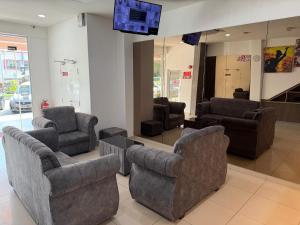 a lobby with couches and chairs and a tv at Hotel Seri Rembau in Rembau
