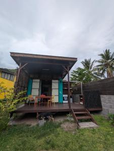 a house with a deck with a table and chairs at Vaianae Sands in Haapiti