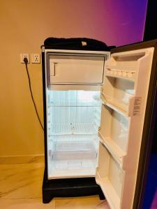 an empty refrigerator with its door open in a room at Bahria 777 Luxury Apartment in Lahore +6 photos