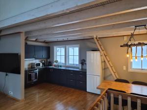 a kitchen with black cabinets and a wooden table at Tjeldsund Tide nr. 6 in Steinsland