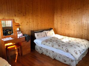 a bedroom with a bed and a wooden wall at Ming Zhen Homestay in Gukeng