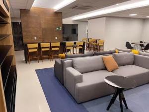 a living room with a couch and a table and chairs at Apart Blend Marista Ar, Cozinha Próx ao Órion in Goiânia